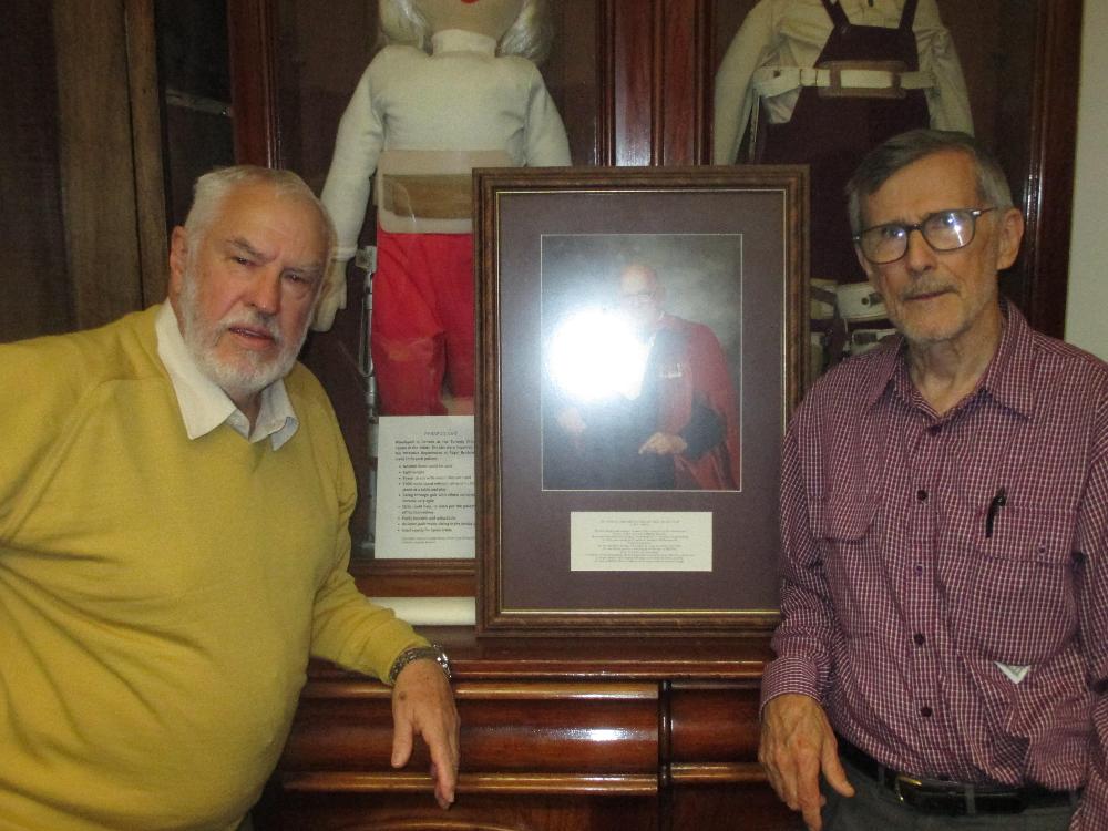 Merv Cobcroft and Jim Nixon pose with a portrait of Otto Hirschfeld
