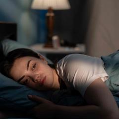 Sad woman lying in bed 