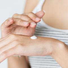 close up of a lady applying hand cream.