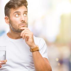 Man thinking while drinking a glass of water