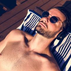 man tanning on daybed wearing sunglasses