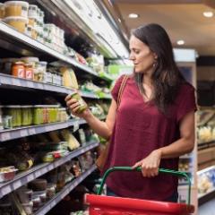 Woman holding a jar at a supermarket aisle 
